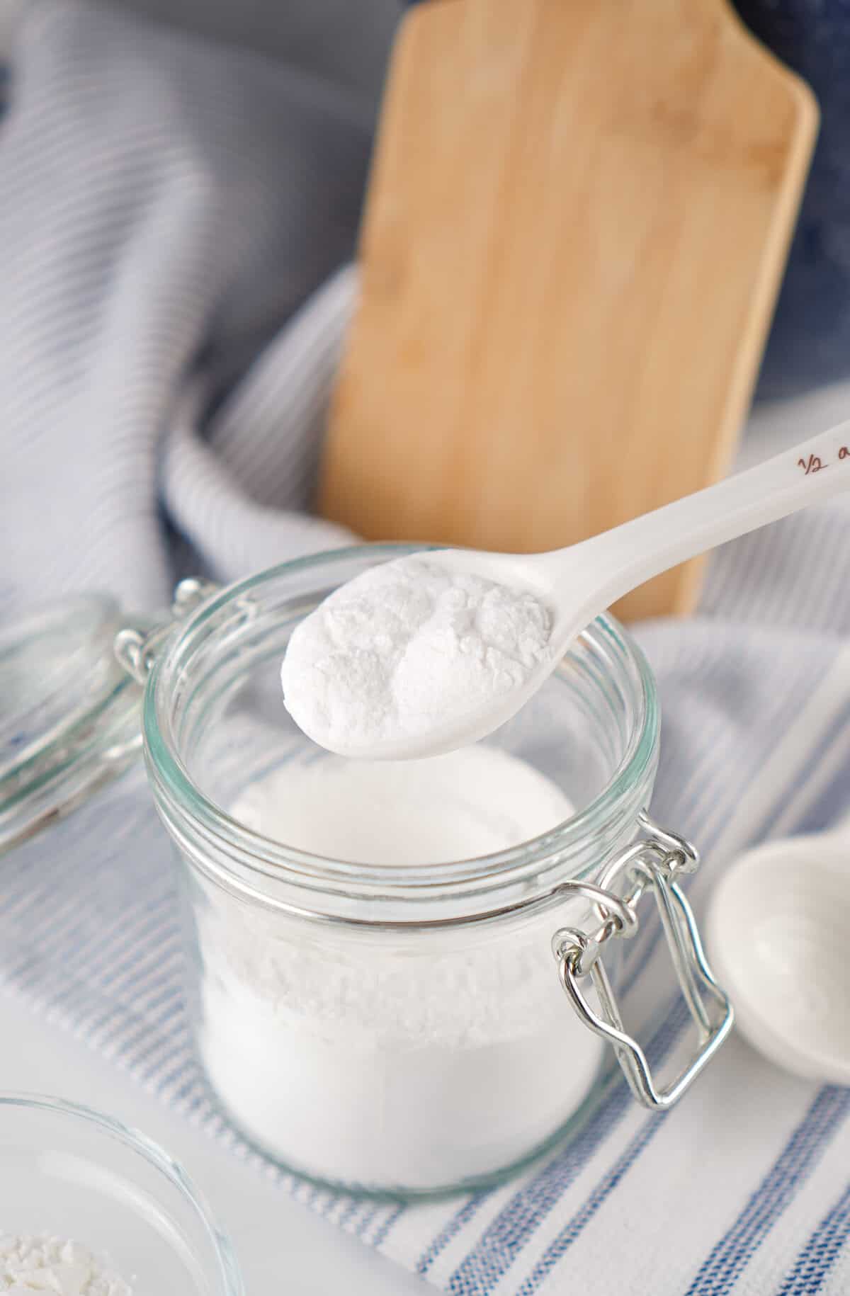 homemade baking powder in a small clear jar with spoon