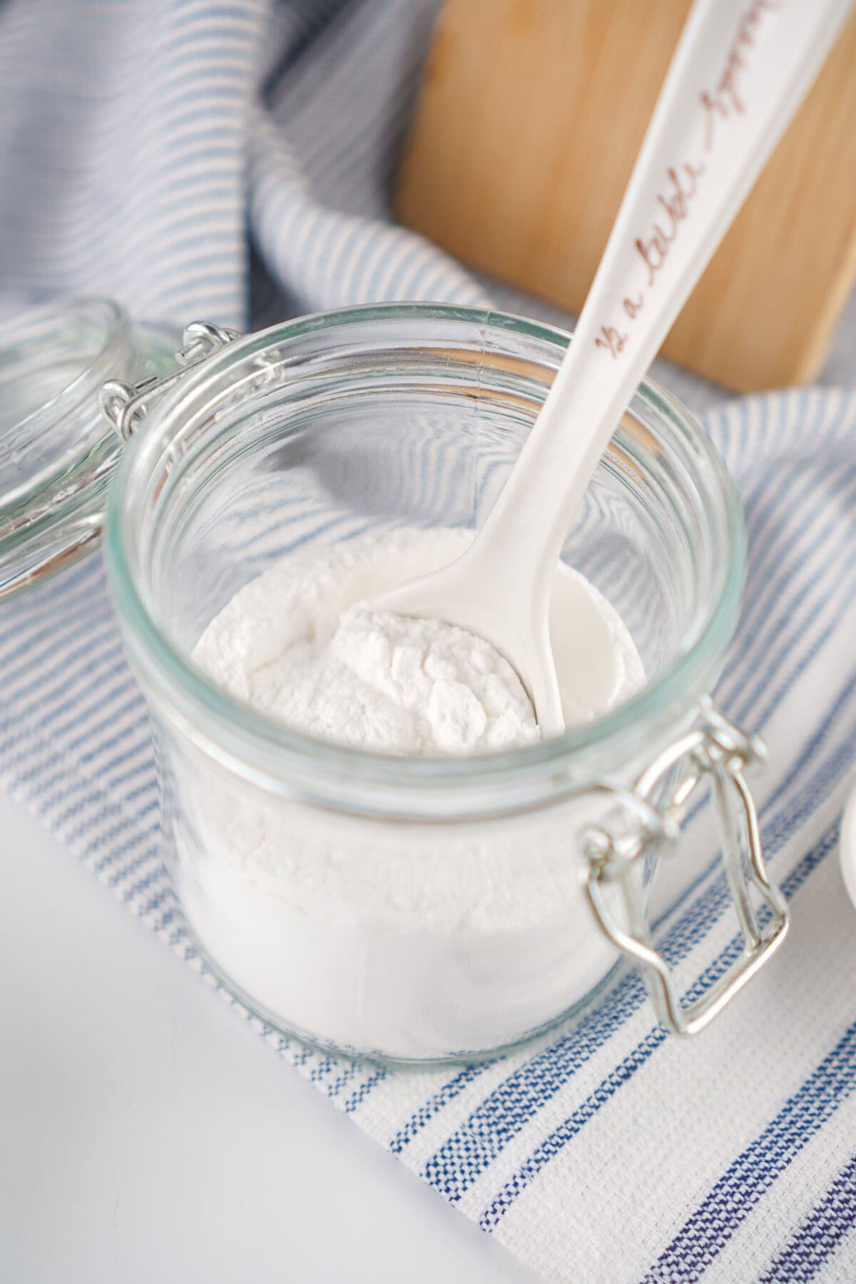 a jar of baking powder with a measuring spoon in it