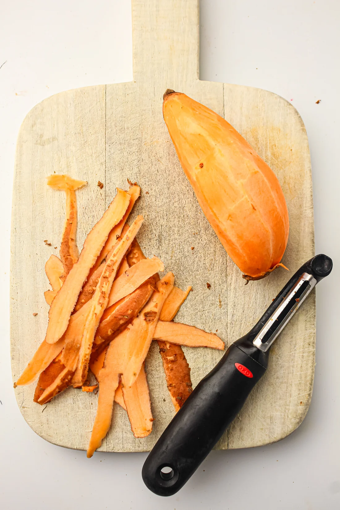 peeled sweet potato on a cutting board