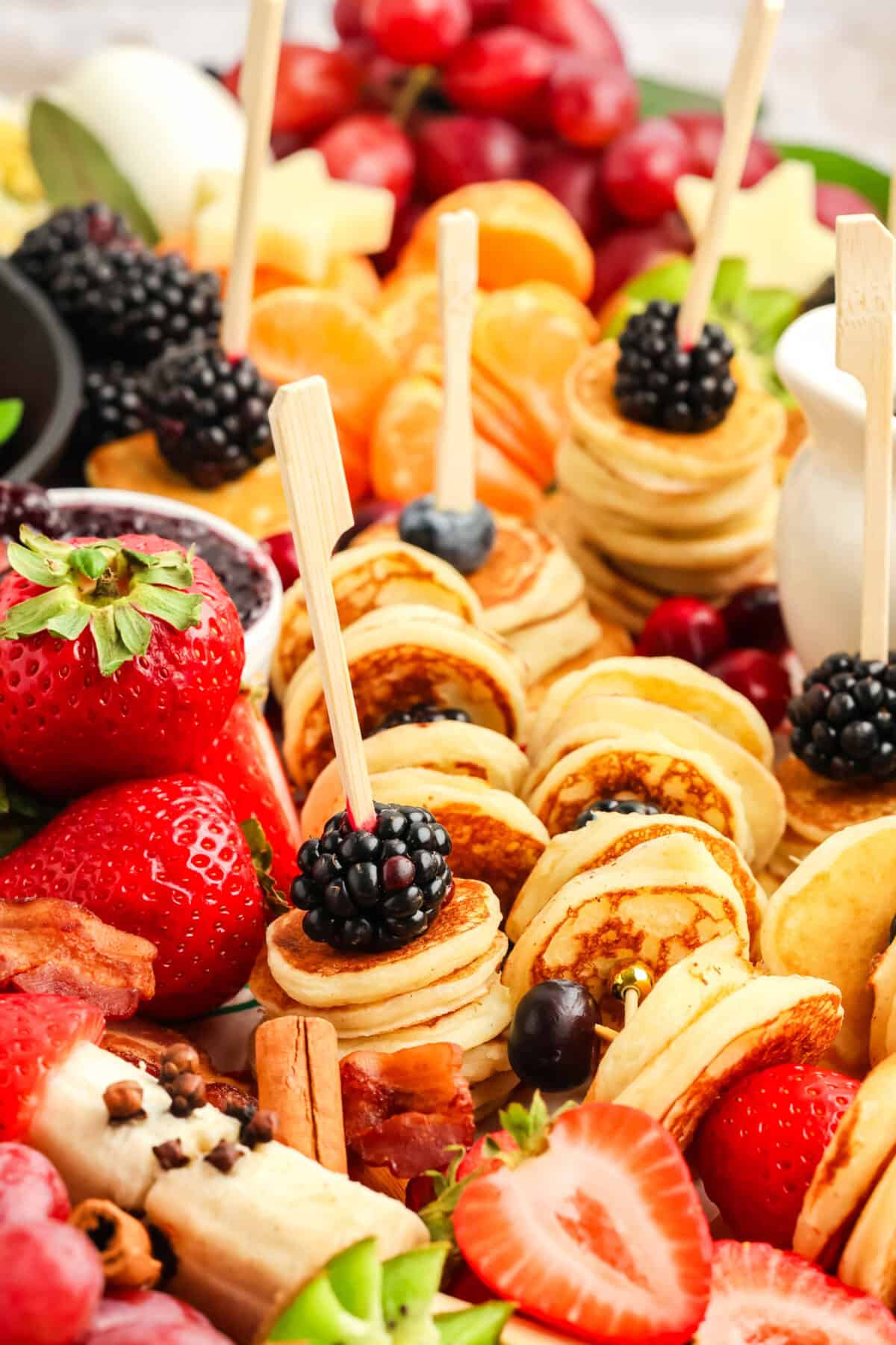 stacks of mini pancakes with fruit and a skewer through them