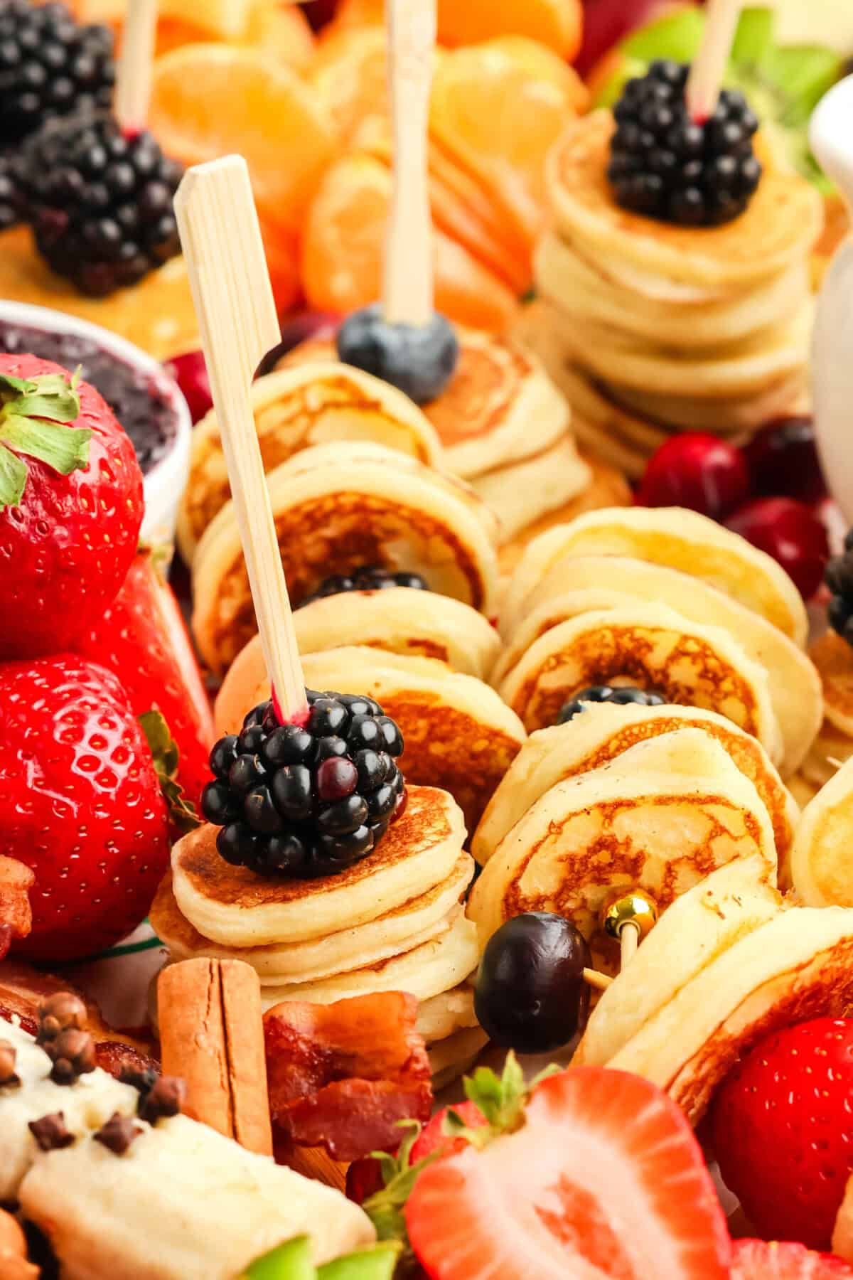 stack of mini pancakes with fruit and a fork