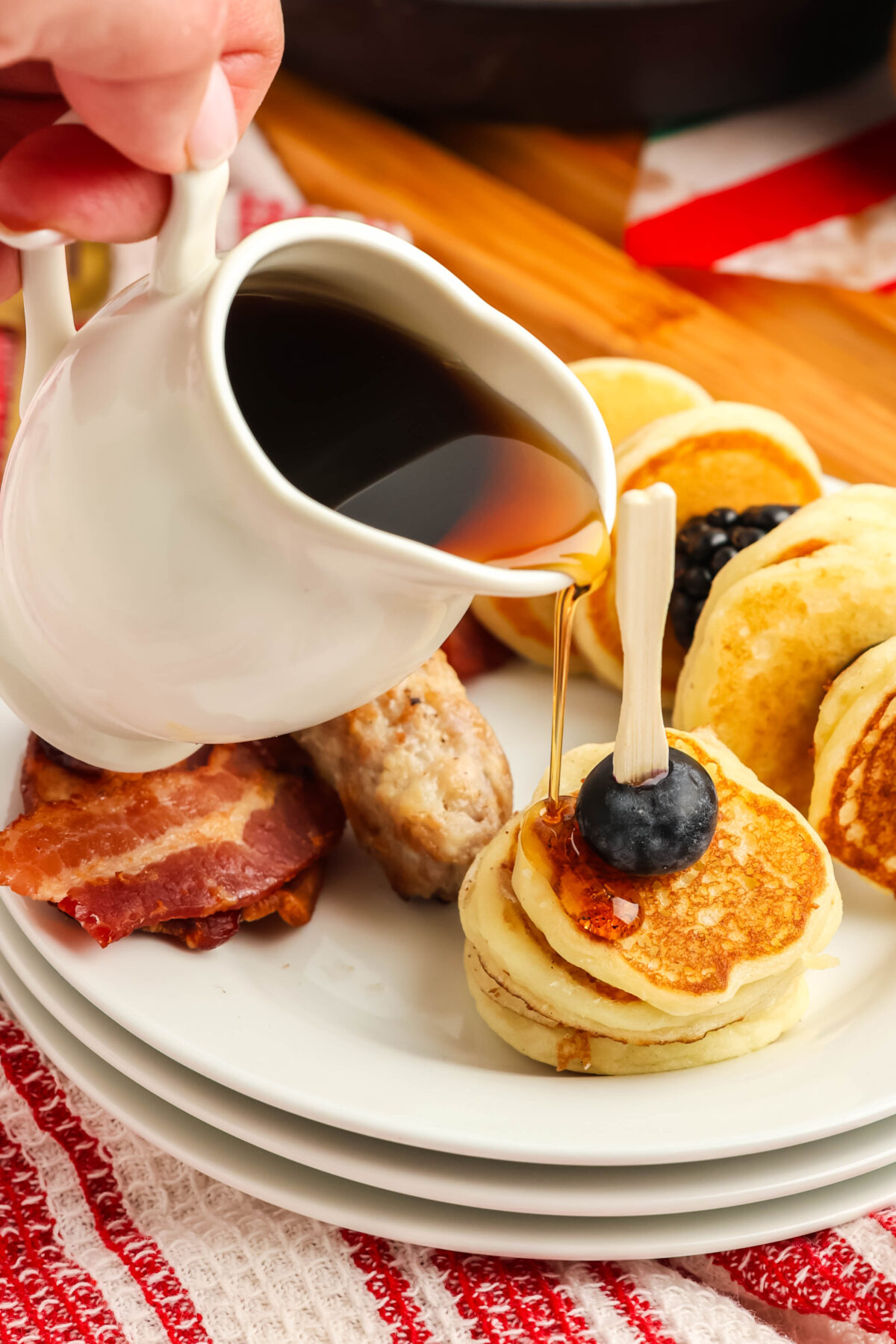mini pancakes with syrup being poured over the top