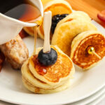 mini pancakes with syrup being poured over the top