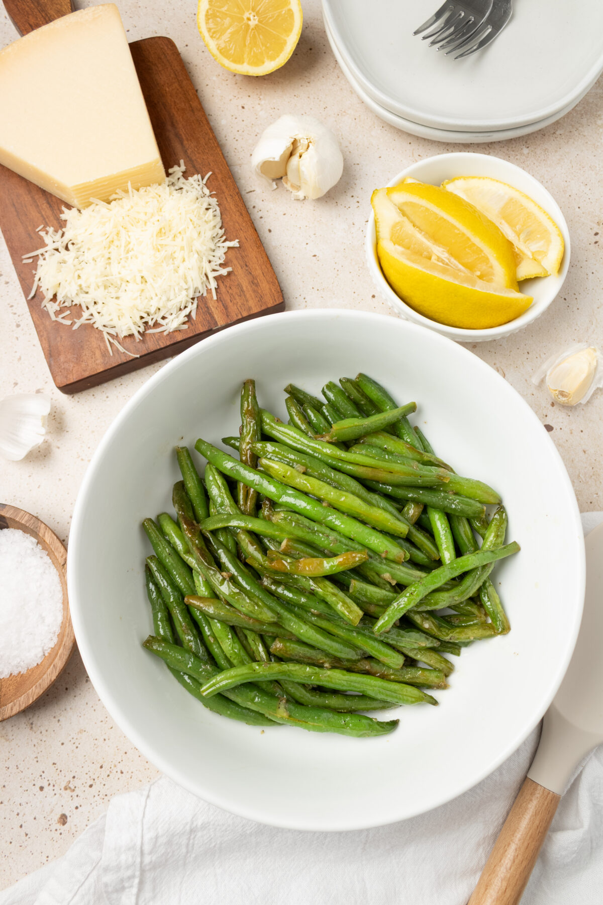 sauteed green beans with shredded parmensan on white plates