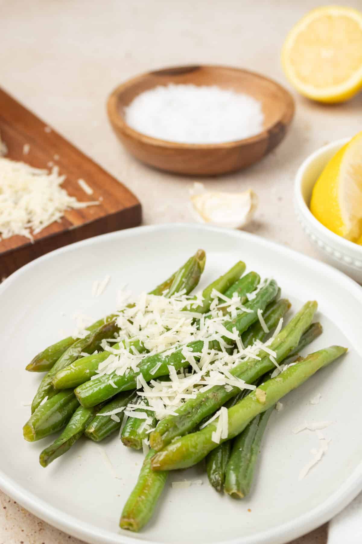 Sauteed Green Beans in a white bowl topped with parmesan