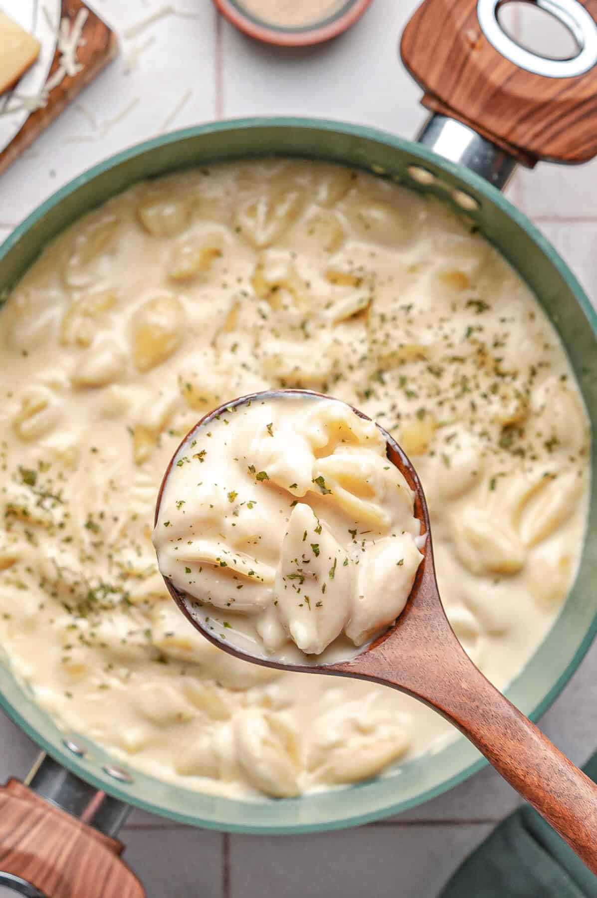 white cheddar mac and cheese in a pot with a spoon