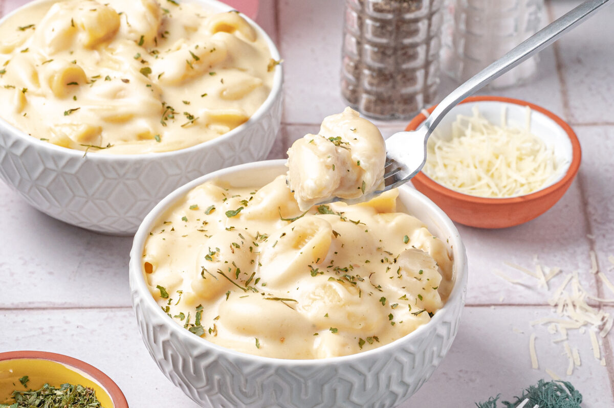 white cheddar mac and cheese in a bowl with a fork